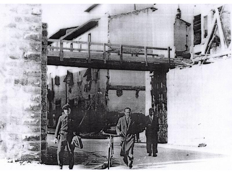 Siamo negli anni della ricostruzione 1946/7/8, si costruisce il nuovo ponte a monte del vecchio di circa 200mt,.sulle fondamenta del quale, è costruita la passerella pedonale. Nella foto si vede il muraglione e la passerella di legno. Per far posto al ponte saranno rimosse le macerie di alcune case
Gli uomini ritratti in questa foto sono: con la bicicletta Enzo Cecchi  presidente della cooperativa di ricostruzione, Terzani Enzo, e dietro sulla sinistra Giulio Casalini.